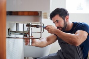 AdobeStock_322035345 plumber fixing pipes